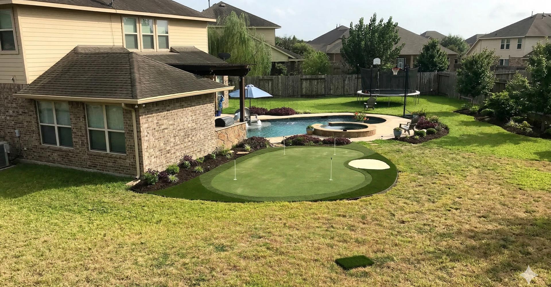 Banner image of a backyard artificial-turf putting green near a poolside