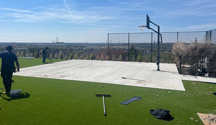Professional team installing artificial grass on a basketball court