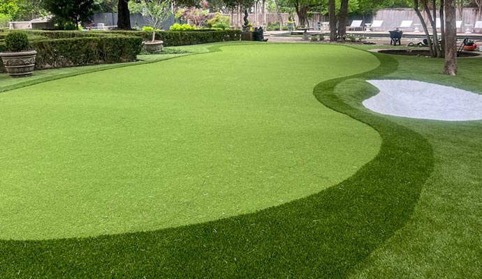 Artificial turf putting green installed in a backyard designed for golf practice