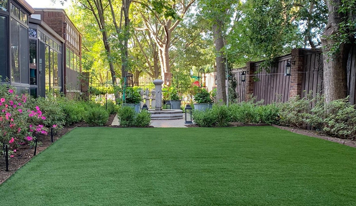 A residential backyard fully covered with artificial turf