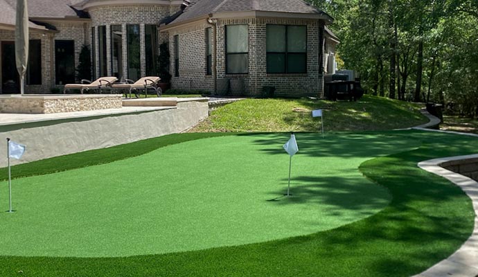 A residential backyard golf court with synthetic turf